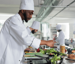 African chef cooking in professional kitchen